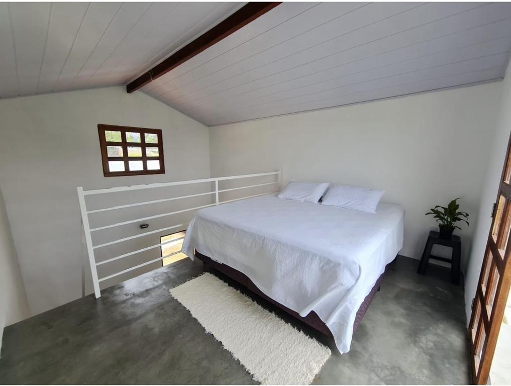 Chalés Jacumã Paradise في جاكوما: غرفة نوم بسرير ابيض ونافذة