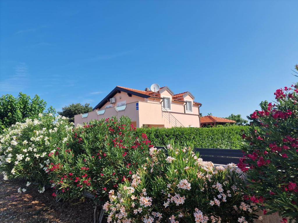 a house on top of a hedge with flowers at Villa Verbena in Mala Čista
