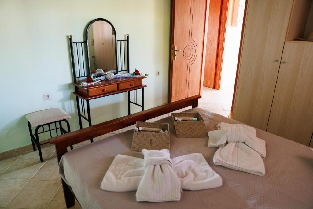 1 dormitorio con 1 cama con toallas y espejo en ATLAS Villa, en Kástro Tornéze