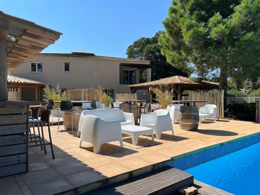 d'une terrasse avec des tables et des chaises blanches à côté de la piscine. dans l'établissement Havre de paix Fiori di Cala Rossa, à Lecci