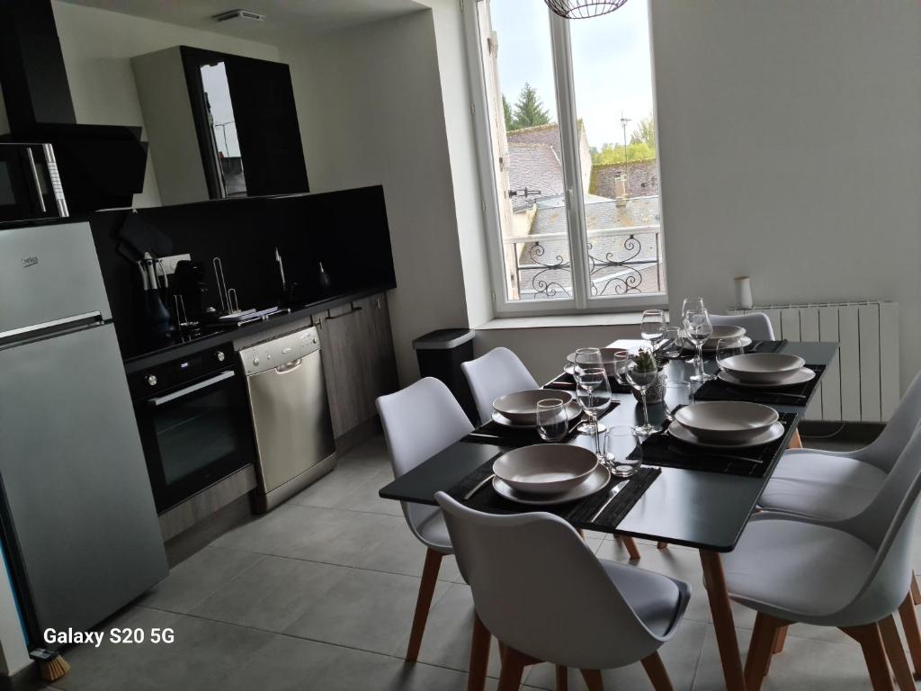 uma sala de jantar com uma mesa e uma cozinha em Serrimmo - appartement Aude em Bléneau