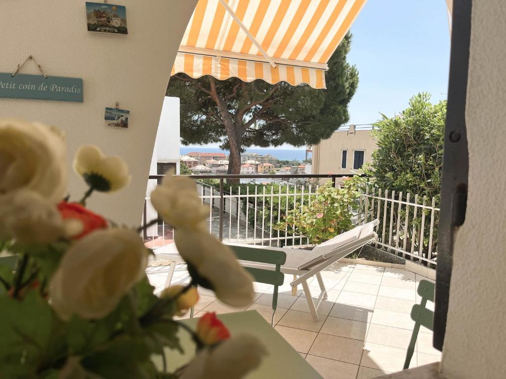 uma vista para uma varanda com uma mesa e flores em Casa La Perla - Alloggio con terrazza panoramica, piscina e free parking em Ceriale