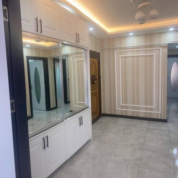 a large room with white cabinets and a room with a door at Şehir Merkezinde Otel Konforunda Family House in Sivas