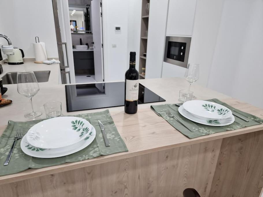 einen Tisch mit 2 Tellern und eine Flasche Wein in der Unterkunft Extreme Confort en Santa Cruz Ciudad in Santa Cruz de Tenerife