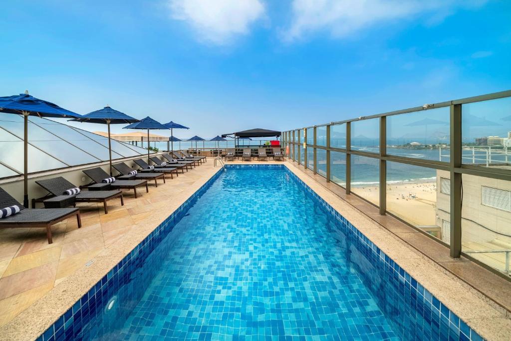 a swimming pool on the top of a building with a beach at JW Marriott Rio de Janeiro in Rio de Janeiro