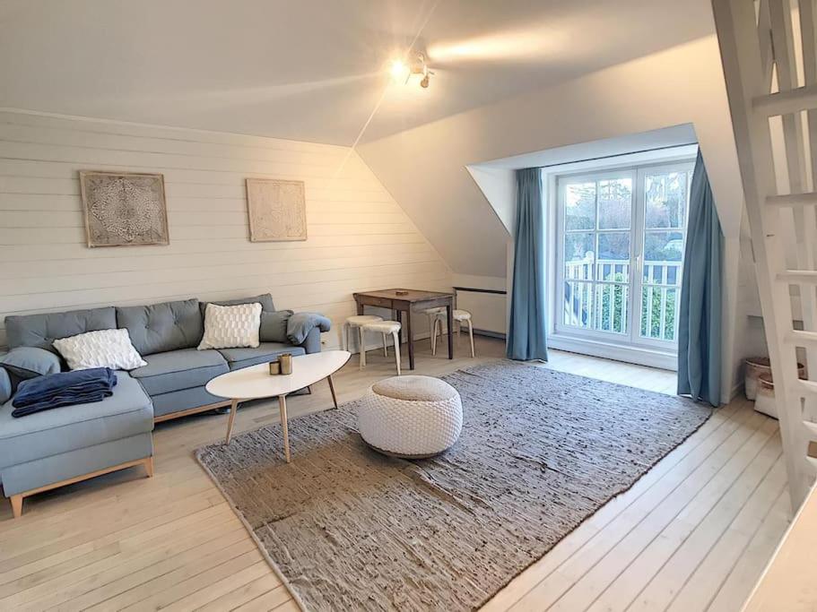 uma sala de estar com um sofá e uma mesa em Cottage en bordure bruxelloise em Wezembeek-Oppem