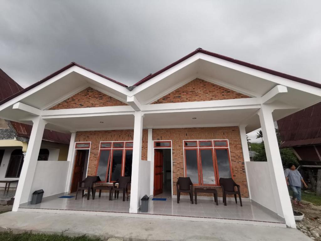 a detached house with a large open patio at Hisar Guest House in Tuk Tuk