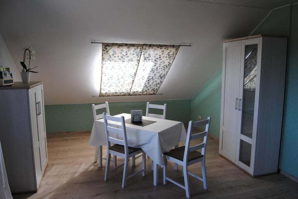 a dining room with a white table and chairs at Ferienwohnung Arnold in Vöhl