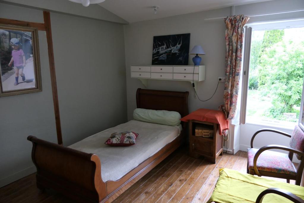 um pequeno quarto com uma cama e uma janela em la chambre du moulin de la bleure em Moncoutant