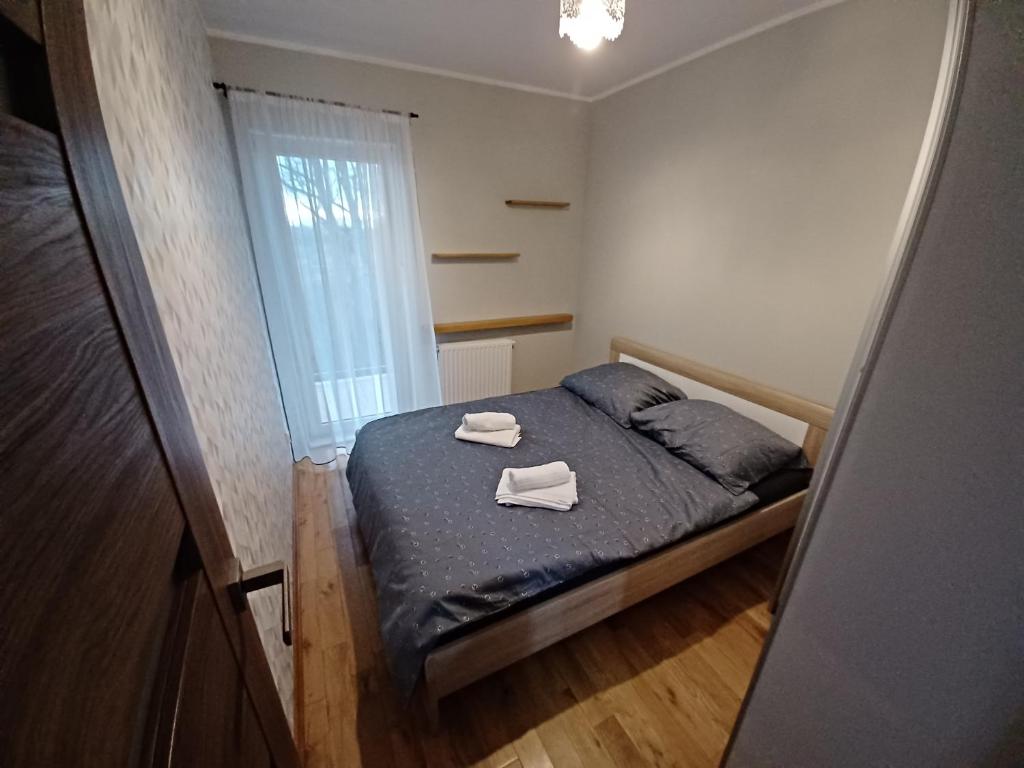 a small bedroom with a bed with two towels on it at Przytulny Apartament w Gnieźnie in Gniezno