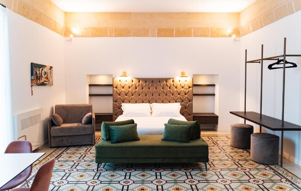 ein Schlafzimmer mit einem Bett, einem Sofa und einem Stuhl in der Unterkunft Le Vie Del Centro Luxury Room in Matera