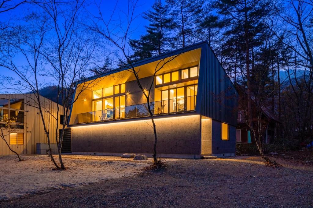 a house is lit up at night at Hakuba Amber Resort by Jade Group in Hakuba