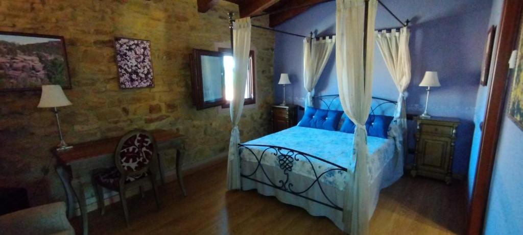 a bedroom with a bed and a table and a chair at Hotel Rural Abuelo Rullo in Terriente