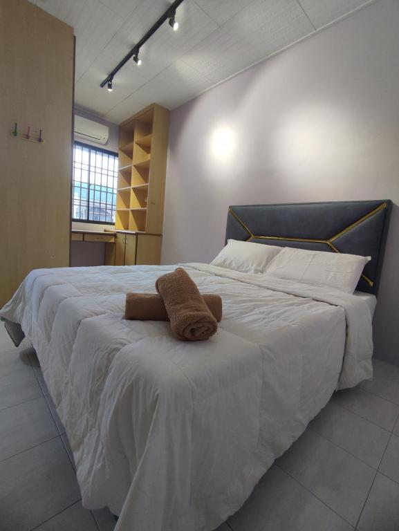 een slaapkamer met een groot bed met een handdoek erop bij Ipoh Tambun Sunway 5 Rooms Spacious Homestay in Tambun