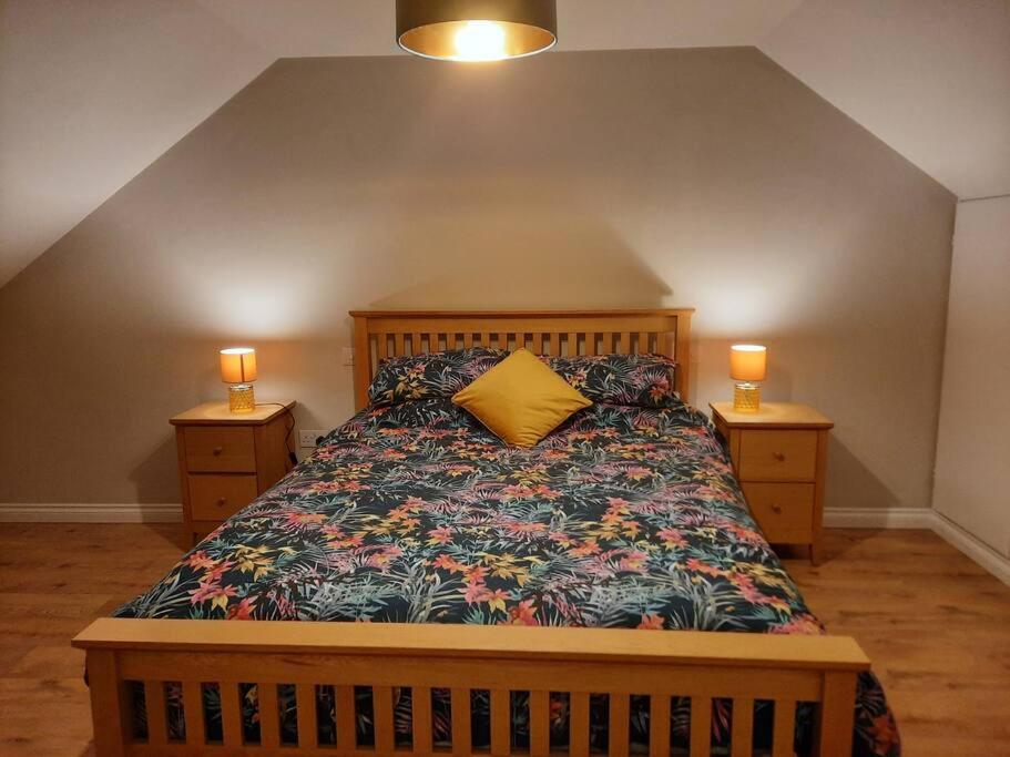 a bedroom with a bed with a yellow pillow on it at Radharc an Chuain 2 Bedroom Holiday Home in Galway