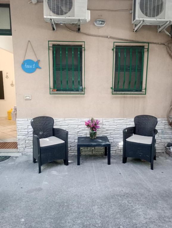 three chairs and a table in front of a building at Matteo's House Taormina in Taormina
