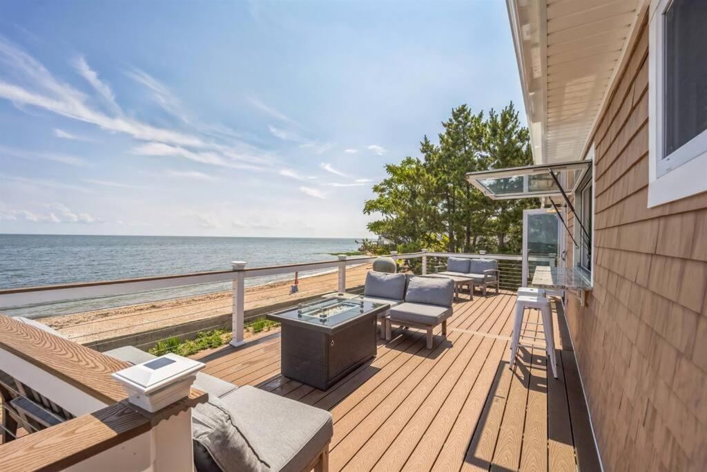 a deck with chairs and a grill and the ocean at Sunrise Cove - Oceanfront Bliss Luxury Beach Retreat in East Haven