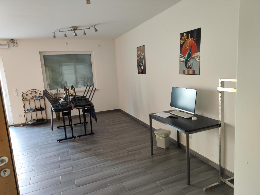 Habitación con escritorio y mesa con ordenador. en Erdgeschoss Wohnung nahe Flughafen en Viena