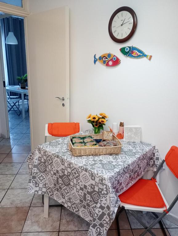a dining room table with a clock on the wall at Matteo's House Taormina in Taormina