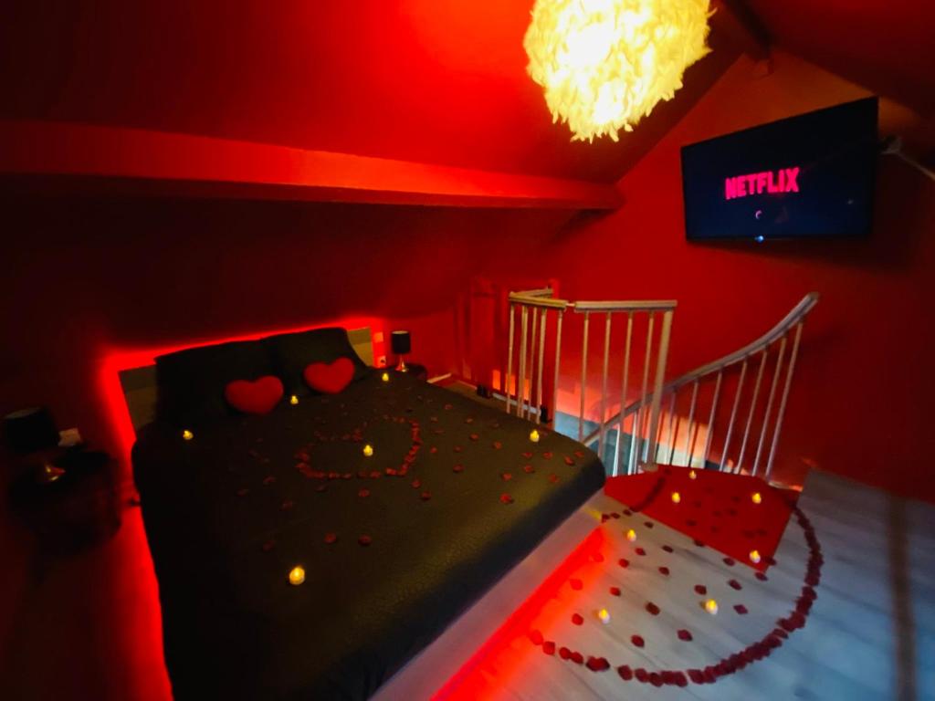 a red room with a bed and a sign on the wall at La Valentine Spa in Béthisy-Saint-Pierre