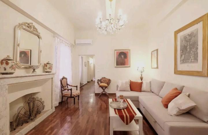 een woonkamer met een witte bank en een open haard bij Appartamento Mira in Lucca