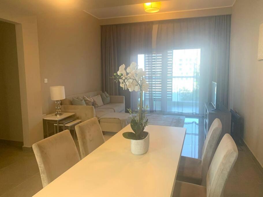 a living room with a white table and chairs at Contemporary 2-Bedroom Apartment in Al Qurayyah