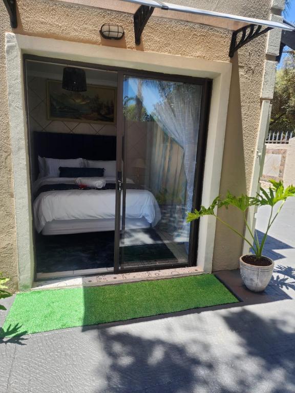 a room with a window with a bed in it at 17 Byvanger Luxury Home Deluxe Queen Suite Room 1 in Centurion