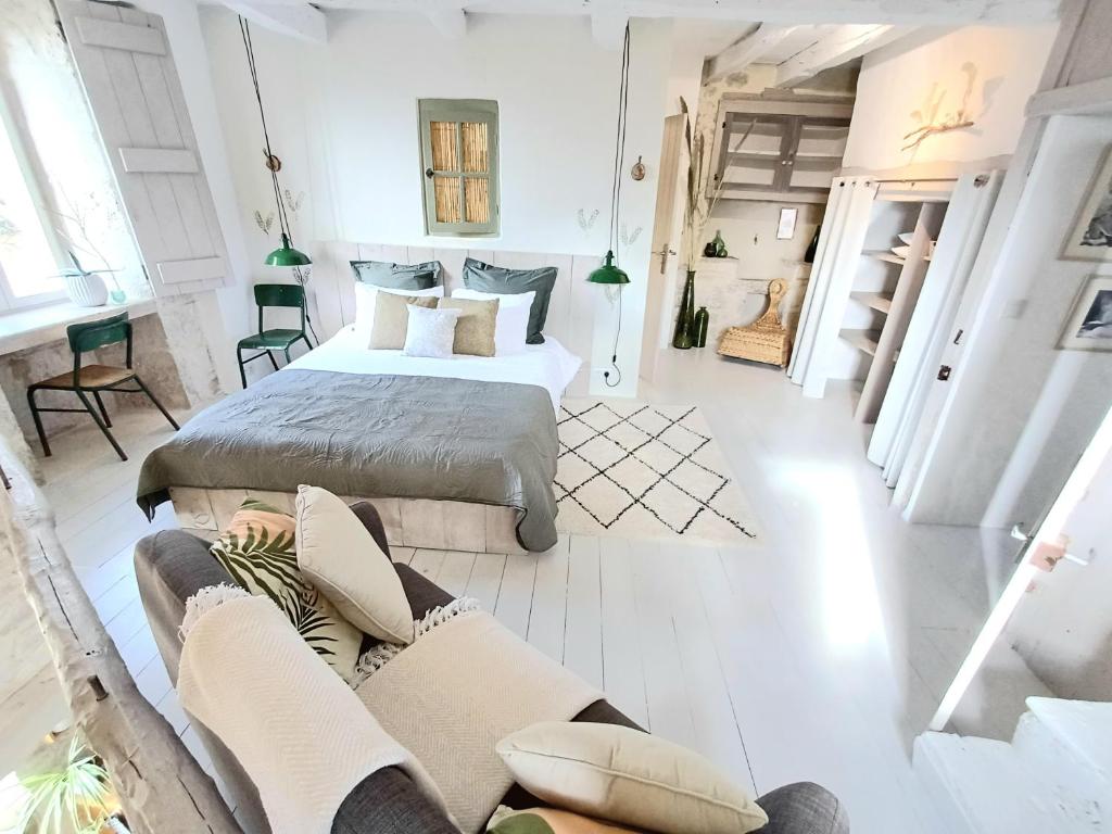 ein Schlafzimmer mit einem Bett und einem Sofa in der Unterkunft Les Terrasses de Flaugnac in Flaugnac