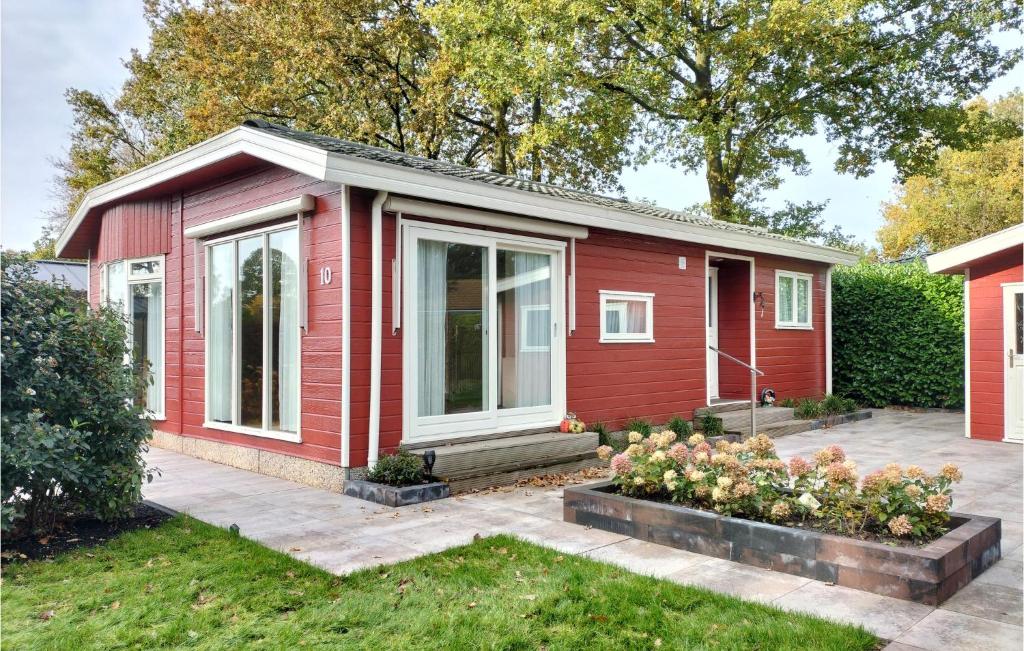 een rood huis met een patio ervoor bij Nice House In Putten in Putten