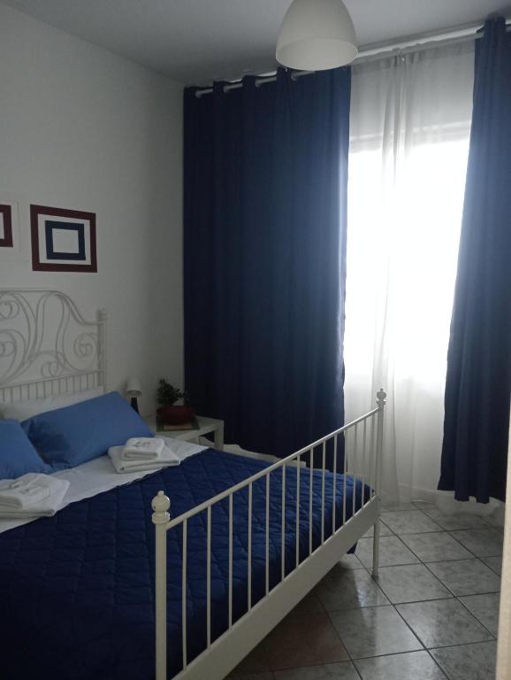 a bedroom with a bed and a blue curtain at Matteo's House Taormina in Taormina