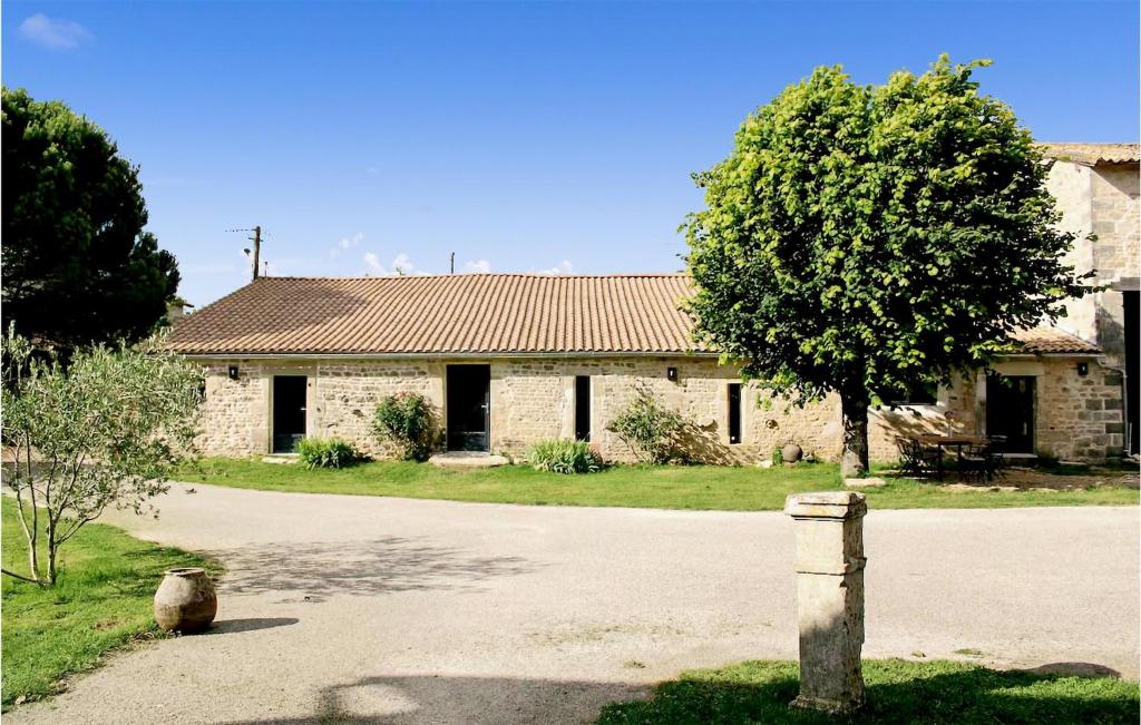 une vieille maison en pierre avec un arbre en face de celle-ci dans l'établissement Stunning Home In Prailles With Outdoor Swimming Pool, à Prailles