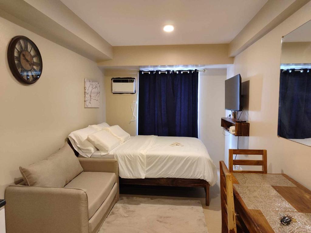 Cette petite chambre comprend un lit et un canapé. dans l'établissement Avida Iloilo T3 624, à Iloilo