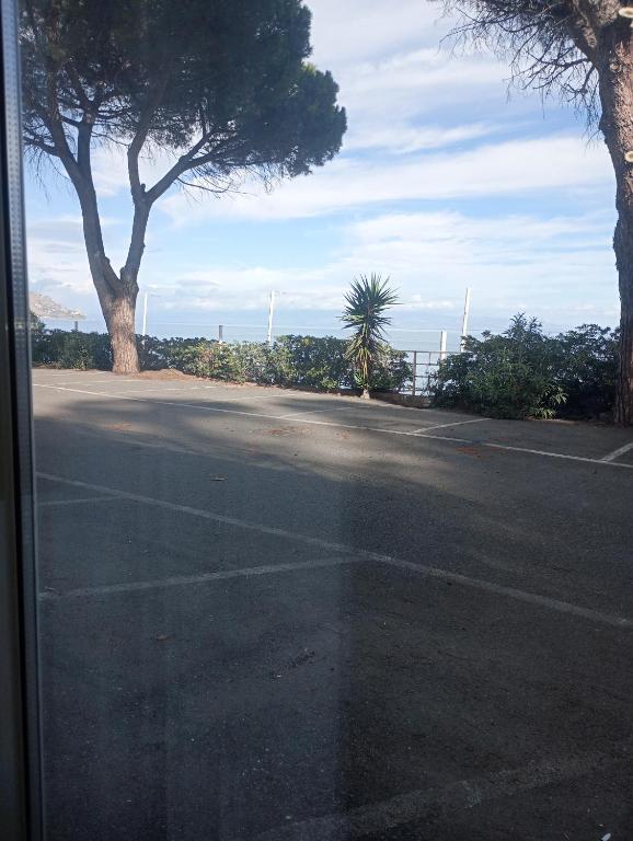 an empty parking lot with trees on the side of the road at Matteo's House Taormina in Taormina