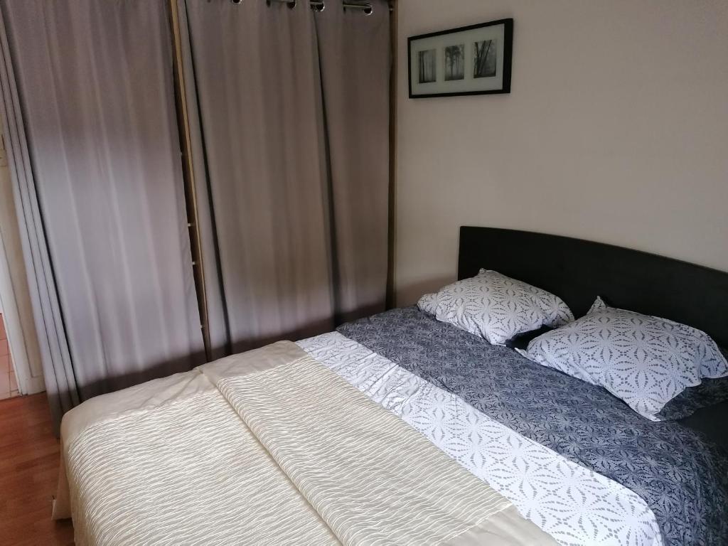 uma cama com duas almofadas num quarto em L'Atelier em Lannion