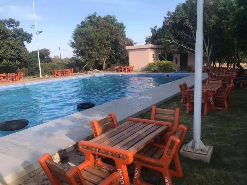 a group of chairs sitting next to a swimming pool at Centre Ecotouristique de Bagré in Saré