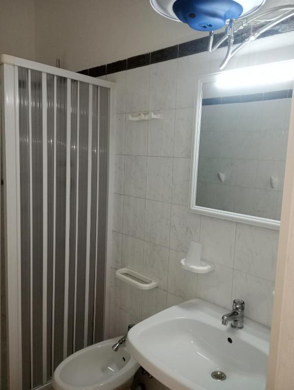 a white bathroom with a sink and a mirror at Matteo's House Taormina in Taormina