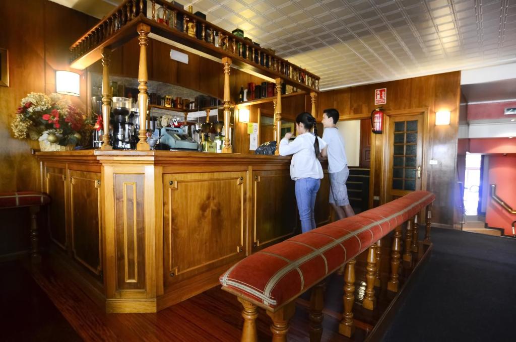 a man and a woman standing at a bar at Hotel Jucamar in Cangas de Morrazo