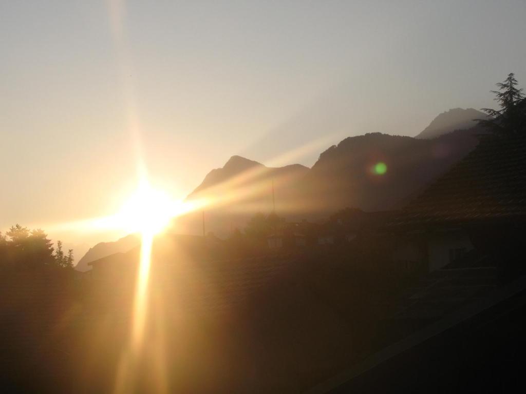 a sunset in the mountains with the sun setting at Bed and Breakfast Le Central in Grône