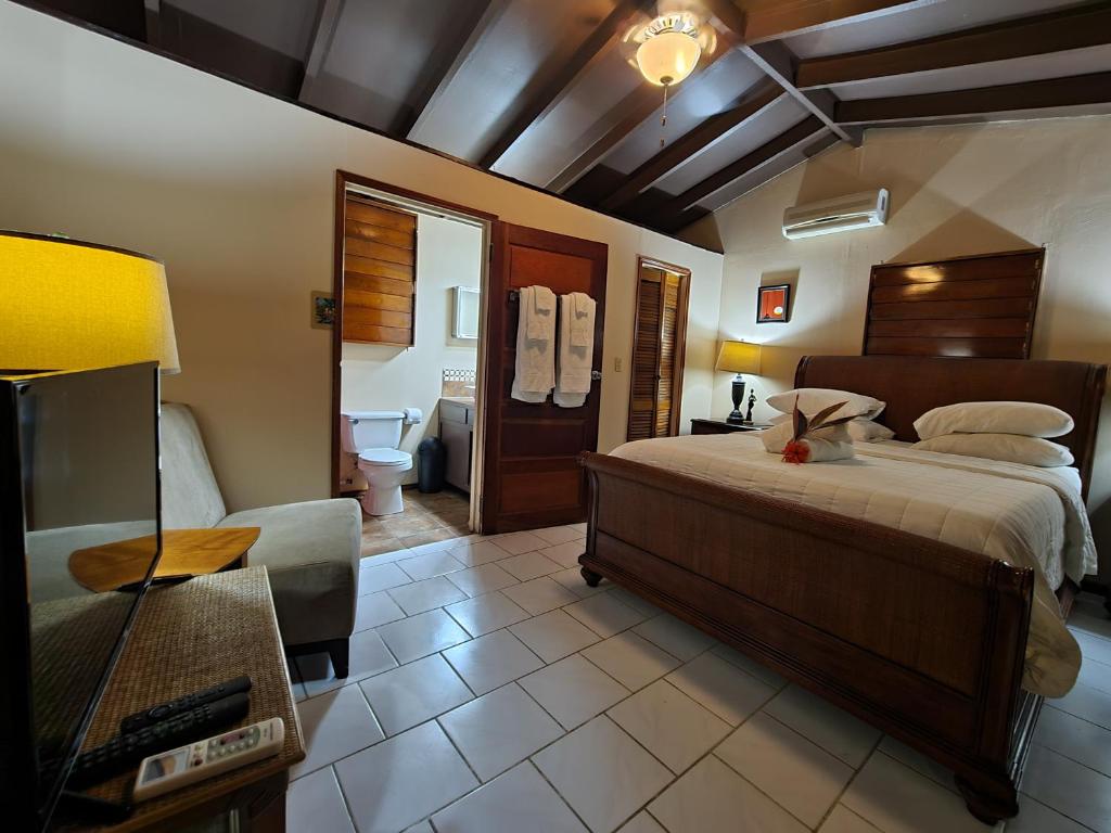 a bedroom with a large bed and a bathroom at Yocamatsu in Caye Caulker