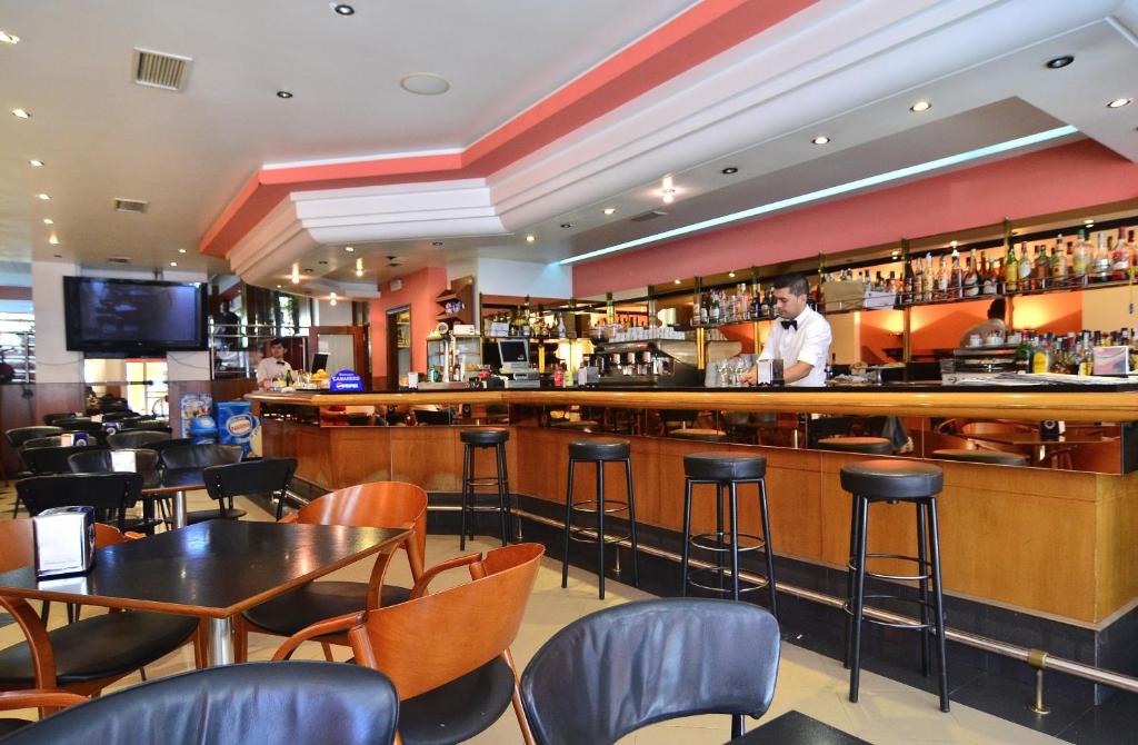 a bar in a restaurant with a man standing at the bar at Hotel Jucamar in Cangas de Morrazo