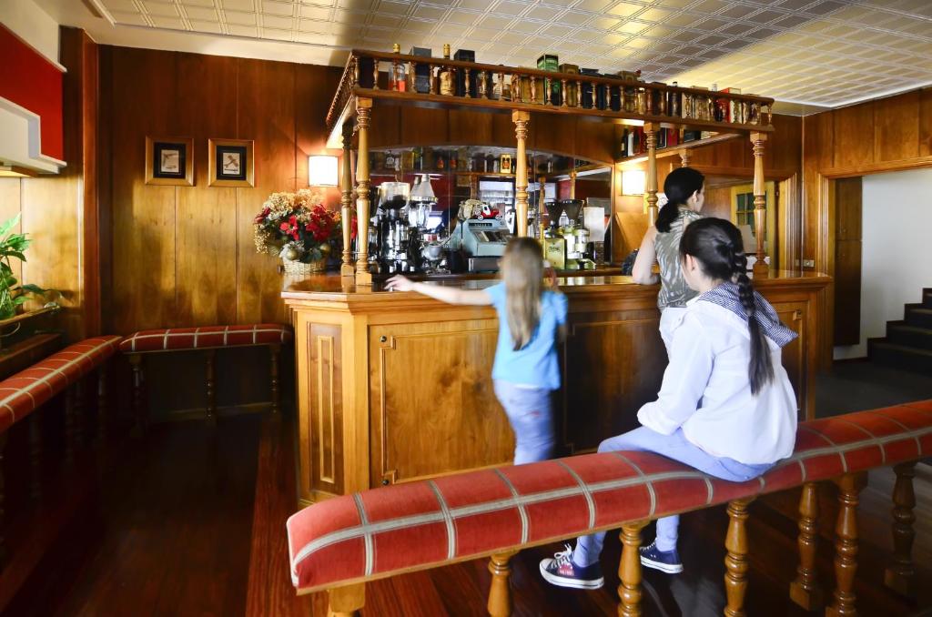 two little girls sitting at a bar in a pub at Hotel Jucamar in Cangas de Morrazo
