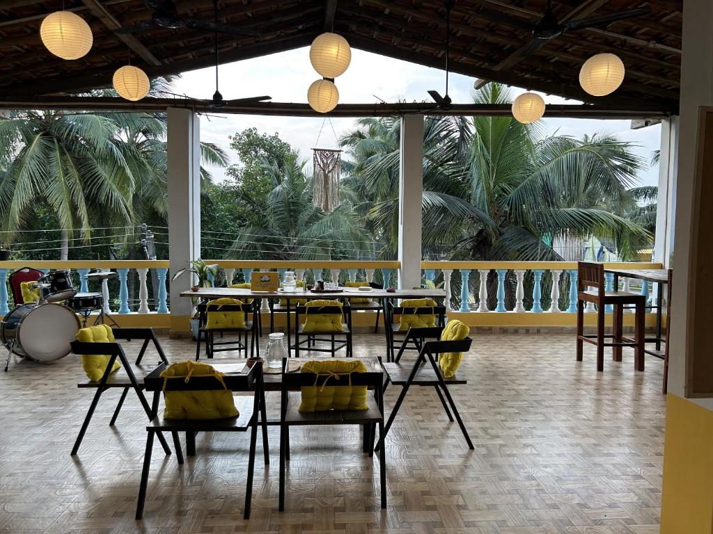 a dining room with chairs and tables and a large window at Iksa in Mandrem