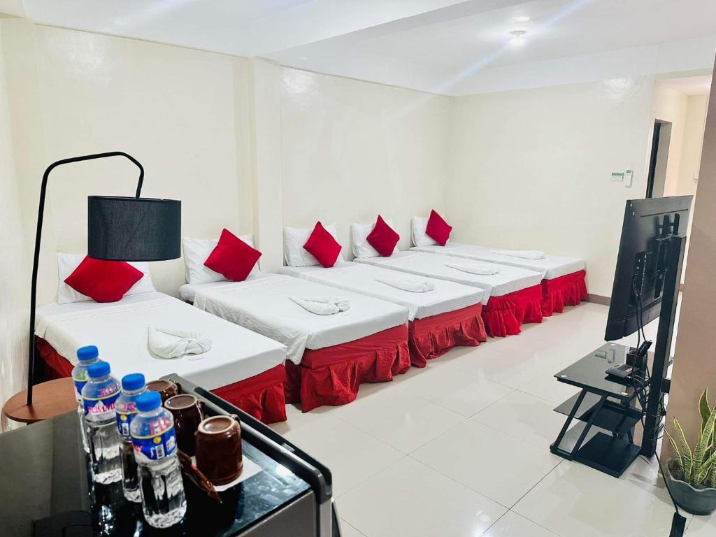 una camera con una fila di letti con cuscini rossi di Red Palm Inn studio room with Netflix a Baybay