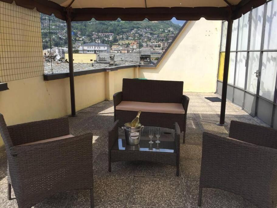 uma varanda com um sofá, 2 cadeiras e uma mesa em Aosta centro storico e splendida vista panoramica em Aosta