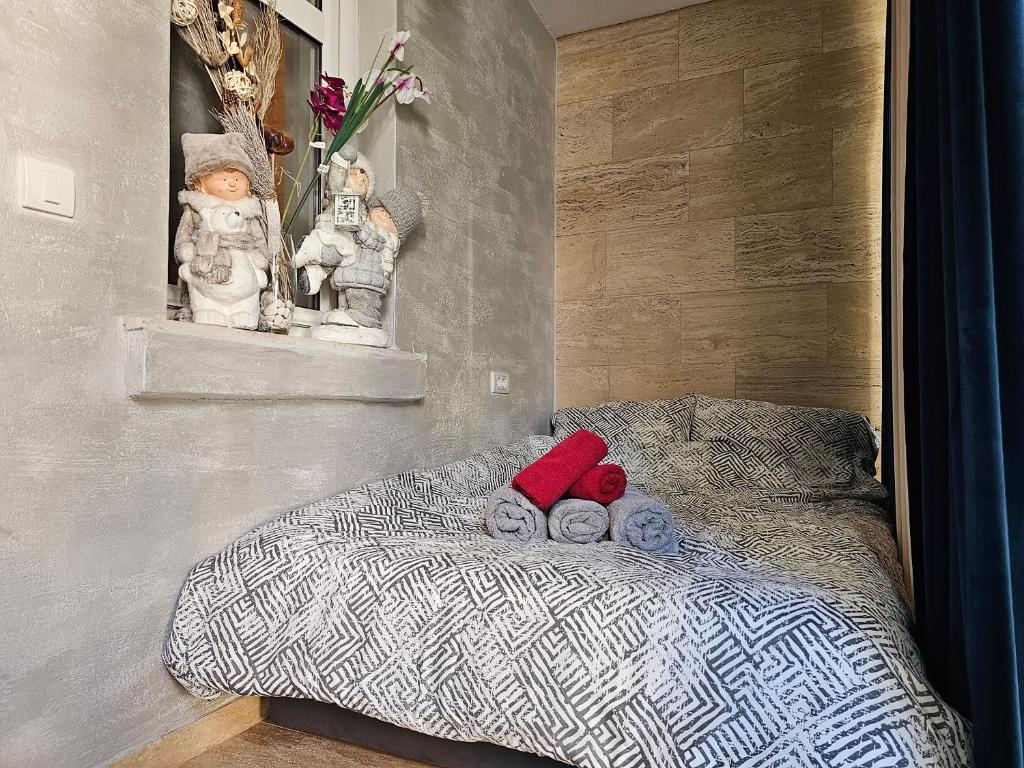 a bedroom with a bed with stuffed animals on it at Apartman Marijana in Novi Sad