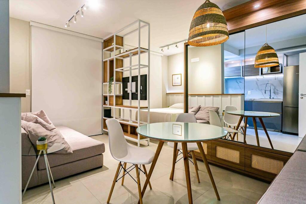 uma sala de estar com uma mesa e um sofá em Design FLAT Wifi 1gb frente Ufsc em Florianópolis