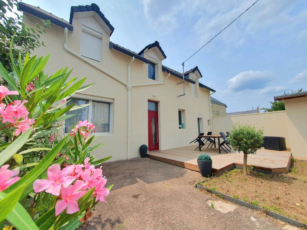 une maison avec une porte rouge et une terrasse en bois dans l'établissement Sweety house, à Brive-la-Gaillarde