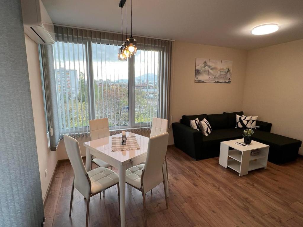 ein Wohnzimmer mit Tisch und Couch in der Unterkunft Апартамент Комфорт 2 Близо до Летището in Sofia