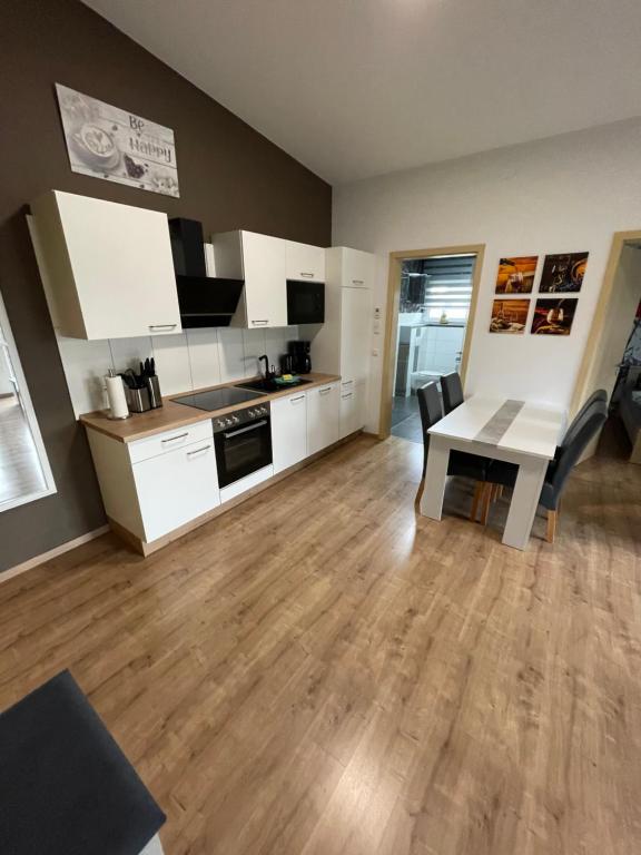 a kitchen with white cabinets and a table in a room at Ferienwohnung Meiwes in Hövelhof