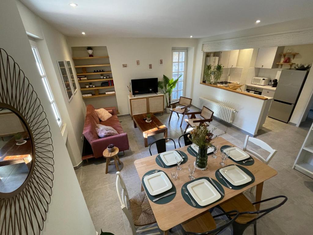 a living room with a dining table and a kitchen at Résidence Léonard - Centre historique Arles in Arles